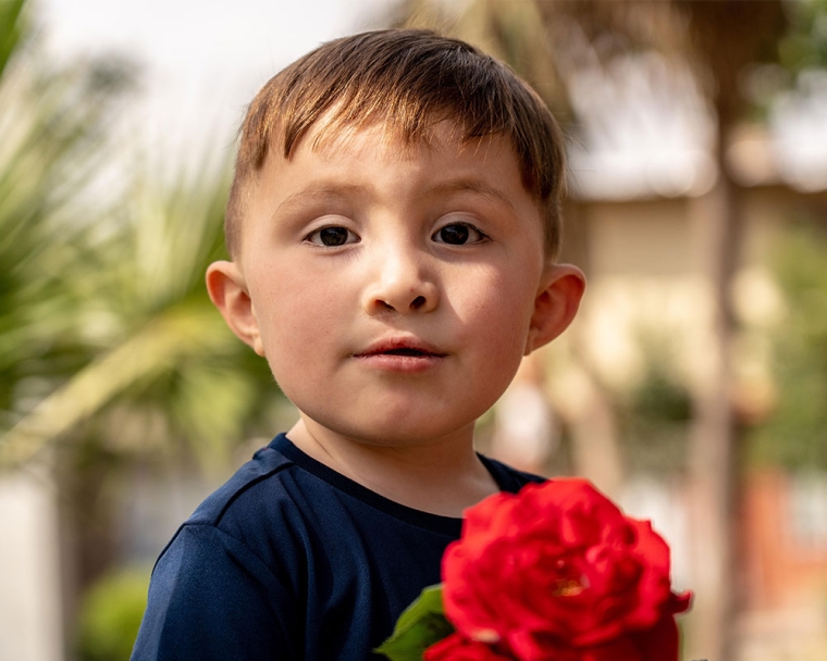 Edden smiling and holding a rose after cleft surgery