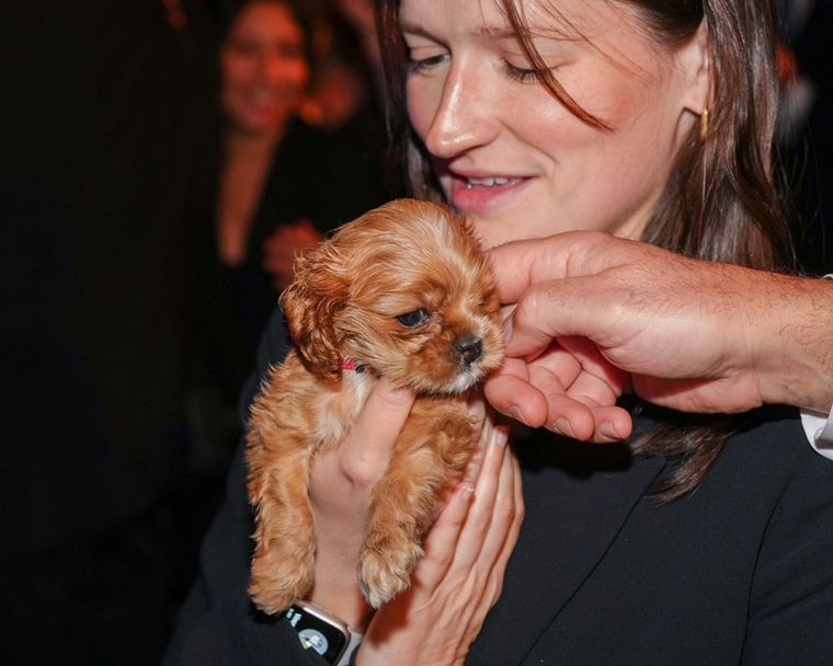 A woman holds a cocker spaniel puppy with a cleft