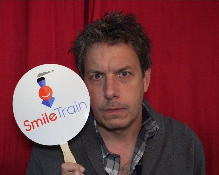 Jon Ross Bowie holding a Smile Train sign