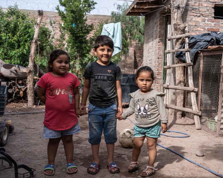 Ezequiel smiling and standing with his sisters after cleft surgery