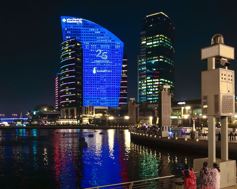 Dubai Festival City lit blue with Smile Train branding at night