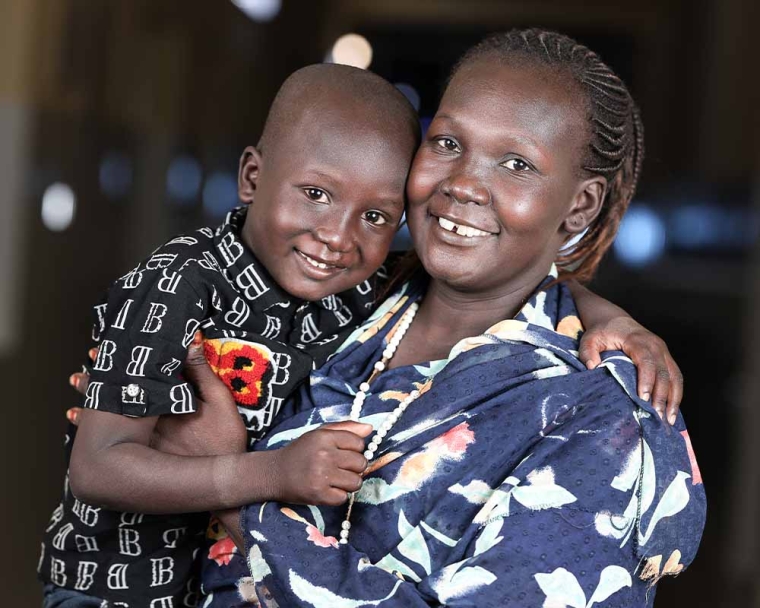 Jacob smiling and hugging his mother Anglina