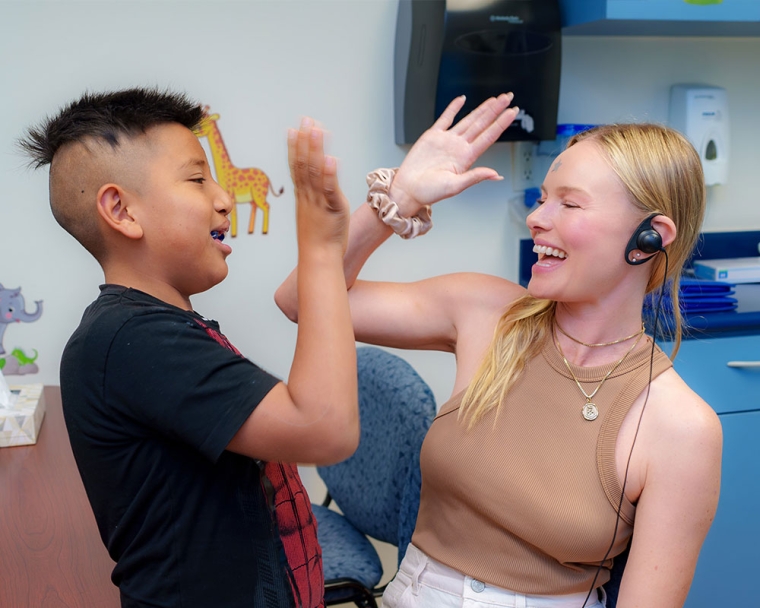 Kate Bosworth giving a high-five to a Smile Train patient after their cleft surgery