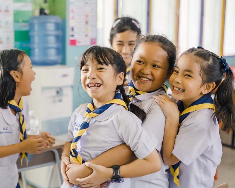 Pim smiling and hugging her friends after cleft surgery