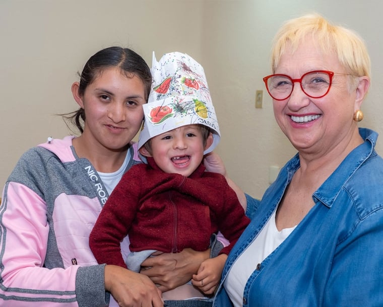 Lidia sharing a smile with a mother and her child with a cleft