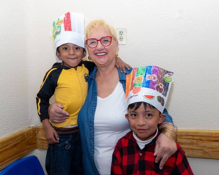 Lidia smiling with two children