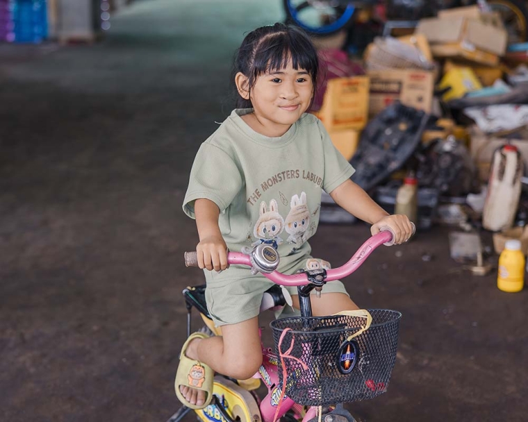 Niu smiling and riding her bike after cleft surgery