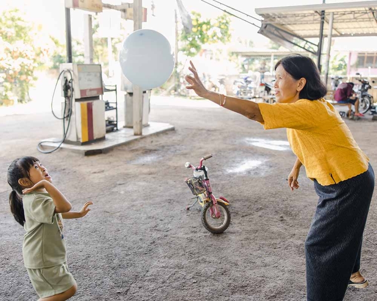 Niu and her grandmother smiling and playing with a balloon after her cleft surgery