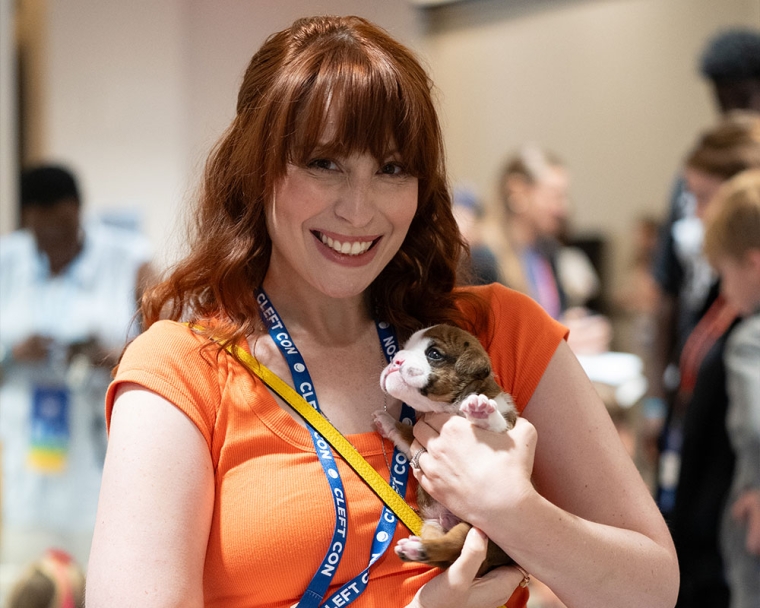 Caitlin Mesiano holds a puppy with a cleft