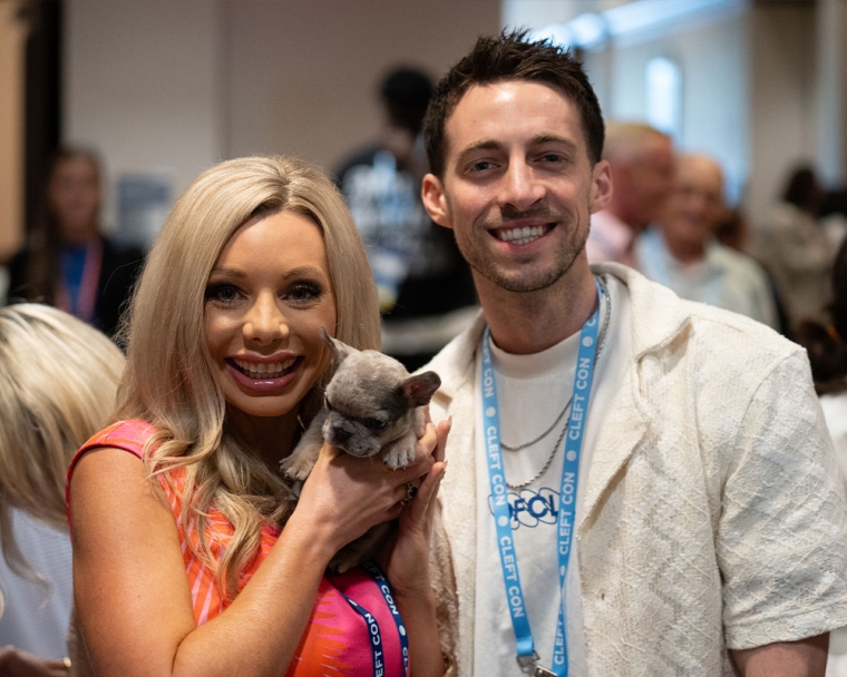 Allie and Adam hold a puppy with a cleft